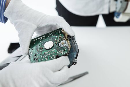 With computer repairman, an owner of small business. Monitors and other laptops in the background waiting for service.の写真素材