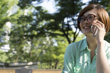 woman using mobile smart phone in the park.の写真素材