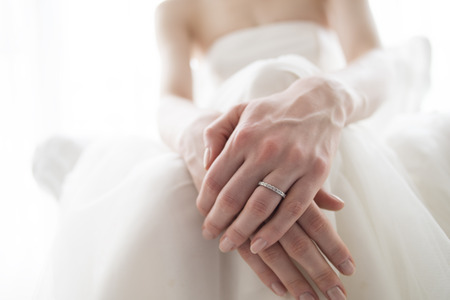 The hands of the bride wearing a wedding ringの写真素材