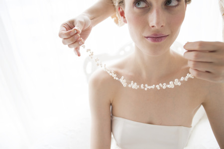 Stylist wears a necklace bride in waiting roomの写真素材