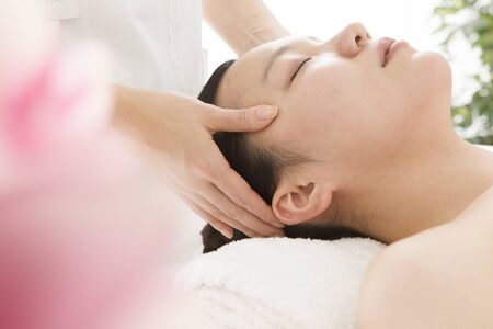 Woman that is massage the head with a Esteの写真素材