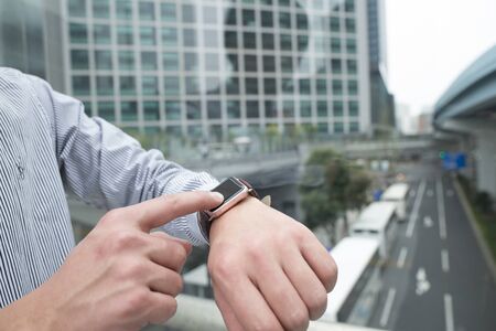 Touch the smart watch while watching the bus.の写真素材