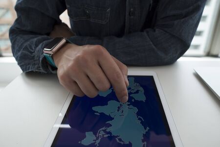 Close-up of a world map and a smart watch