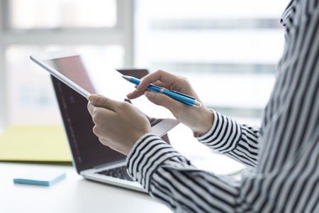 Businesswoman working on smart tablet.