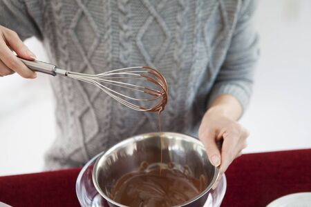 A woman melting chocolate at homeの写真素材