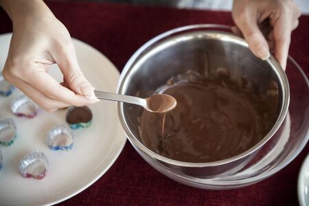 A woman holding a melted chocolate in a moldの写真素材