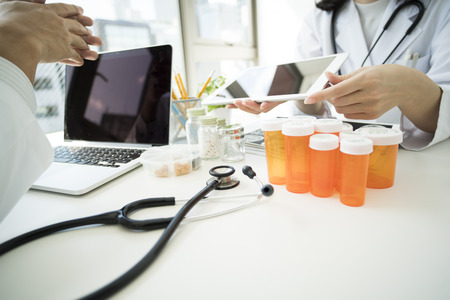 Two doctors consulting while looking at the smart tablet.の写真素材