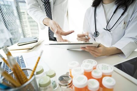 The doctor points to the document at a meeting.の写真素材