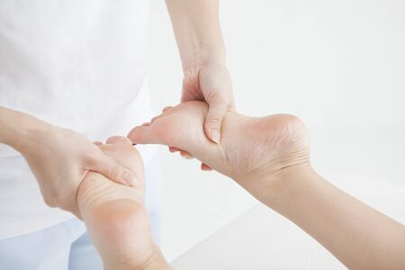 A woman from a chiropractor is massaging a lady's foot.の写真素材