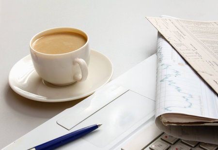 Cup of coffee near the laptop and newspapersの写真素材