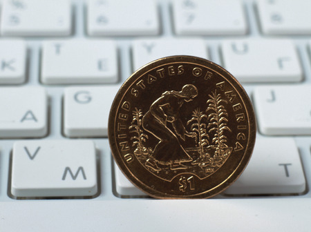 coin on a laptop keyboardの写真素材