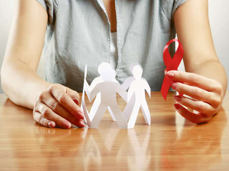 woman taking care about paper people and aids, isolated on grey.