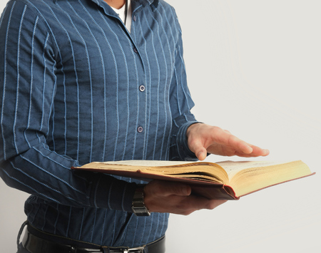 Male hands are browsing through the open book