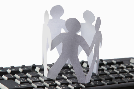 Chain of paper people on the keyboard isolated