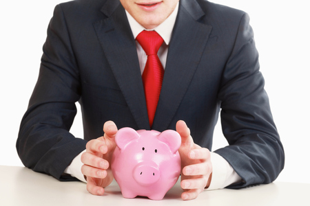 Young man with piggy bank (money box), isolated on white backgroundの写真素材
