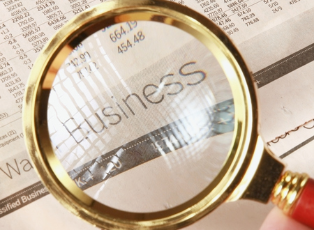 Looking through magnifying glass to financial reportの写真素材