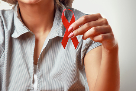 A woman holding  aids red ribbon