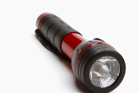 A flashlight lying isolated on white backgroundの写真素材
