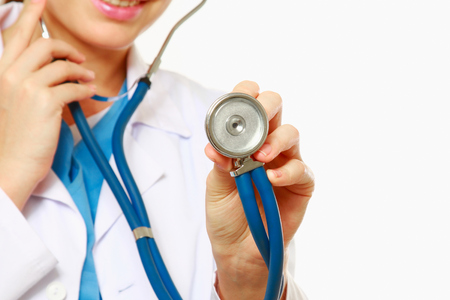 A doctor listening with a stethoscope, close-up, isolated on whiteの写真素材