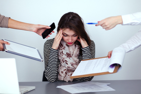 Portrait of tired young business woman with laptop computerの写真素材