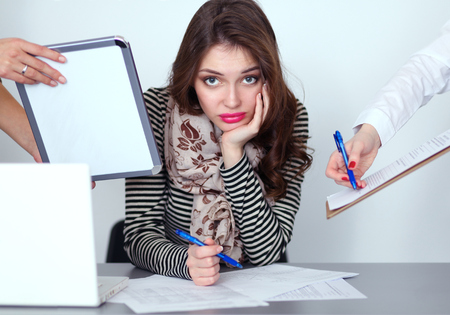 Portrait of tired young business woman with laptop computerの写真素材