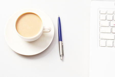 A cup of coffee and a pen near a laptop. Business concept.の写真素材