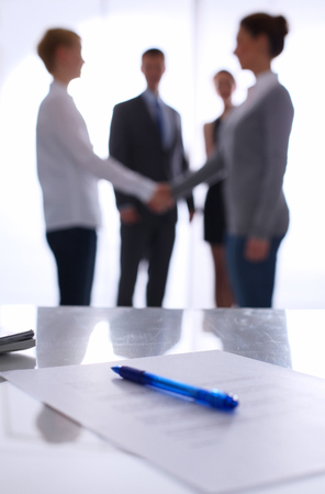 Laptop  computer on  desk ,  businesspeople standing in the backgroundの写真素材