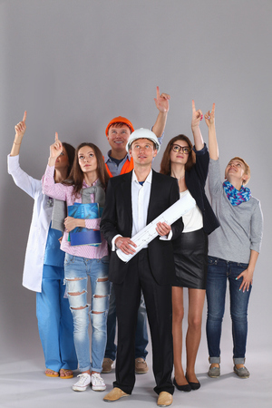 Portrait of smiling people with various occupations and pointing up.の写真素材