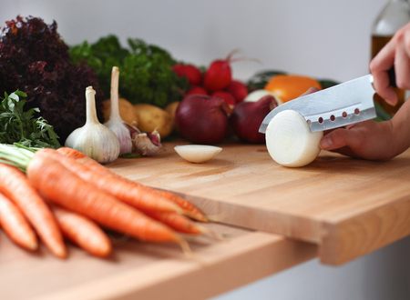 Young woman cutting vegetables in the kitchen .の写真素材
