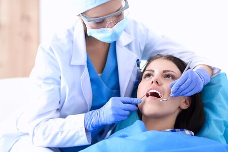 Woman dentist working at her patients teeth .の写真素材