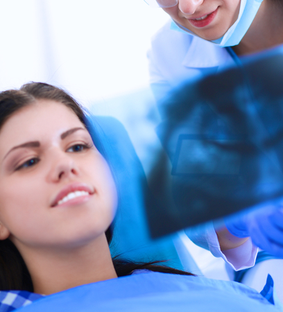 Woman dentist working at her patients teeth .の写真素材