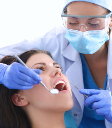 Woman dentist working at her patients teeth .の写真素材