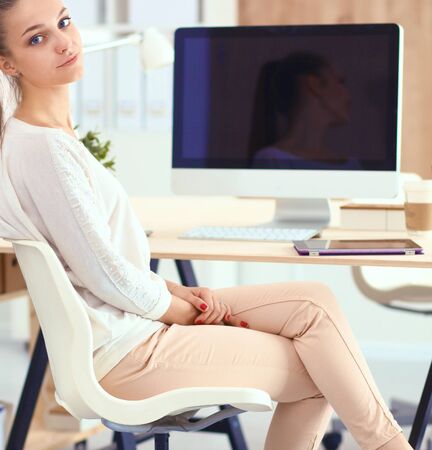 Young woman working in office, sitting at desk.の写真素材
