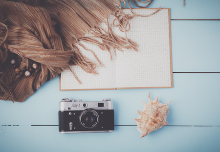 Top view image , open blank notebook, old camera on white wooden tableの写真素材