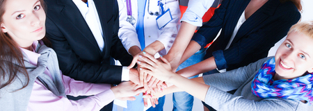 Portrait of people with various occupations putting their hands on top of each other
