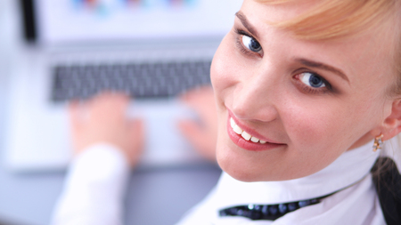 Portrait of  businesswoman sitting at  desk with a laptopの写真素材