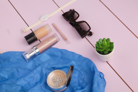 Sunglasses, cosmetics makeup and essentials on wooden backgroundの写真素材