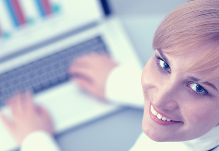 Portrait of  businesswoman sitting at  desk with a laptopの写真素材