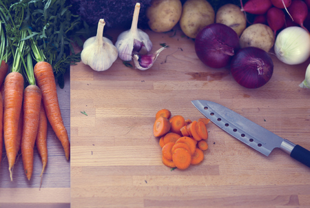 Young woman cutting vegetables in the kitchenの写真素材