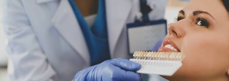 Woman dentist working at her patients teethの写真素材