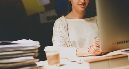 Young woman working in office, sitting at deskの写真素材
