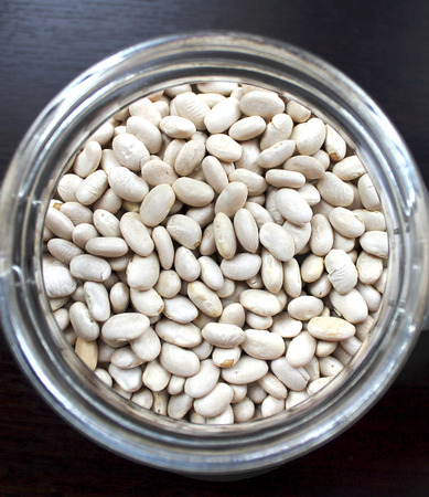 White beans grains in a glass jar on the tableの写真素材