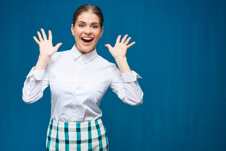Studio portrait on blue of happy woman wearing white shirt.の写真素材