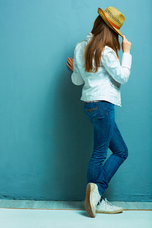 Fashion model standing back against blue.の写真素材