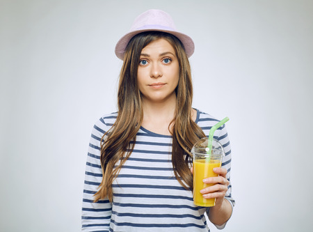 Funny young woman portrait with orange juice glass with straw.の写真素材