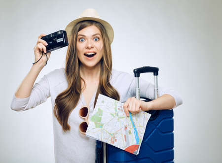 Happy girl traveler holding paper map with camera.の写真素材