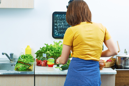 Woman in kitchen cooking vegetable. Woman chef.の写真素材
