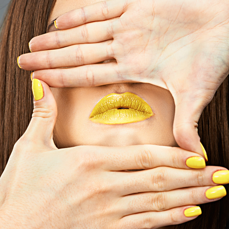 Close up woman face. Glamour make up portrait.Yellow lips and nails.の写真素材