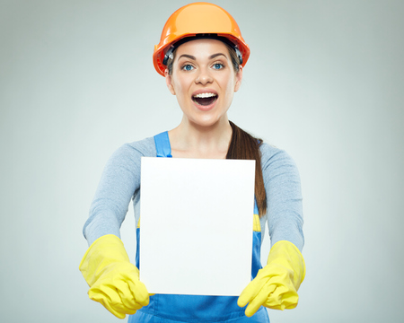 Happy smiling woman builder holding white banner. Isolated studio portrait.の写真素材