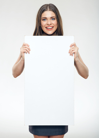 Business woman wearing gray dress holding white sign board against white background.の写真素材
